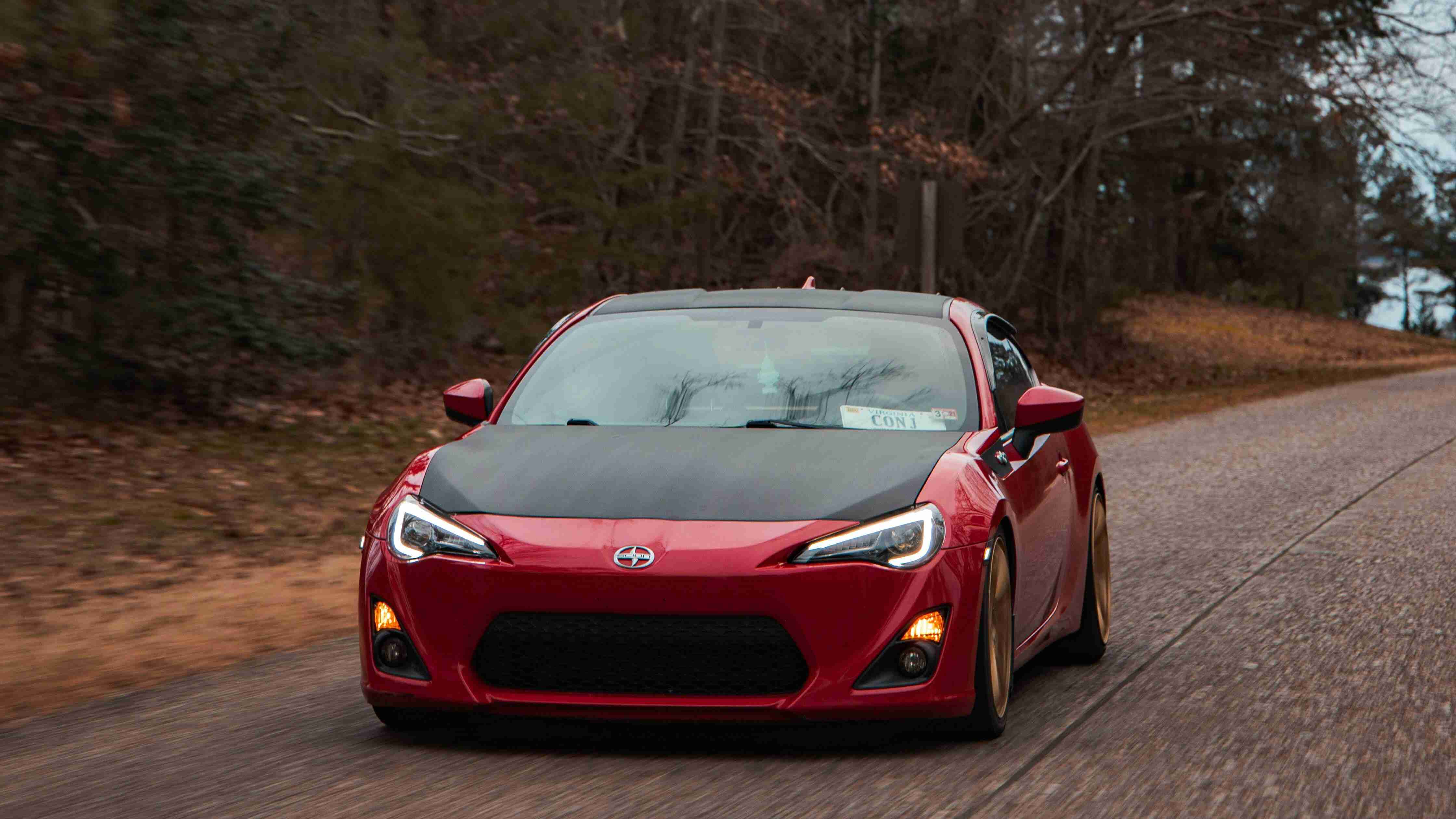 A Sports Car Driving on Asphalt Road