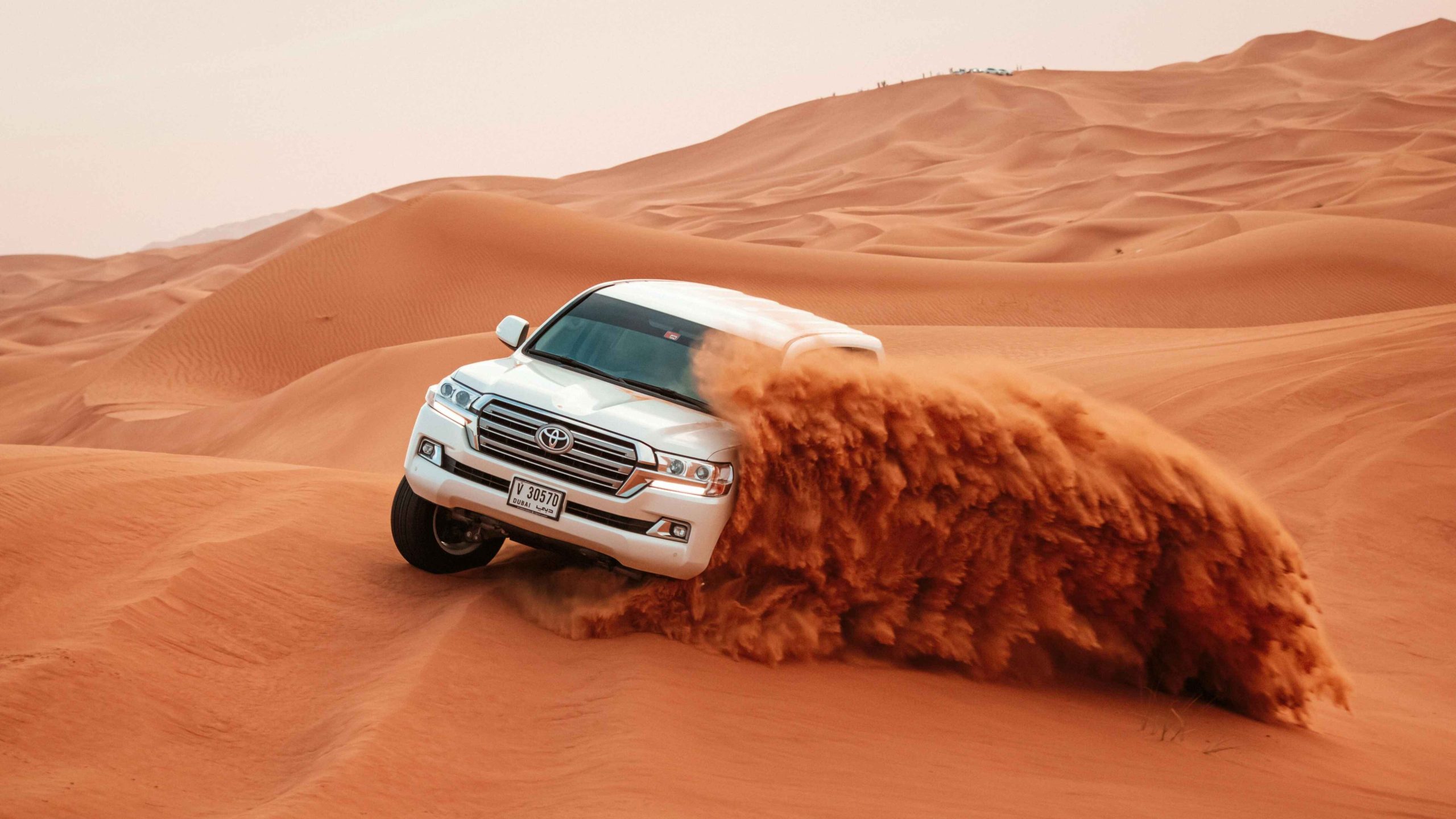 White Toyota Car Driving on Sand Dunes